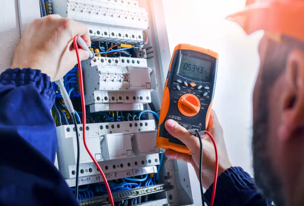 Elektriker som måler spenning i sikringsskap